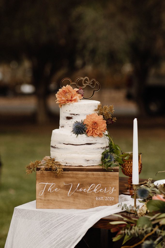 wedding cake with orange and blue flowers